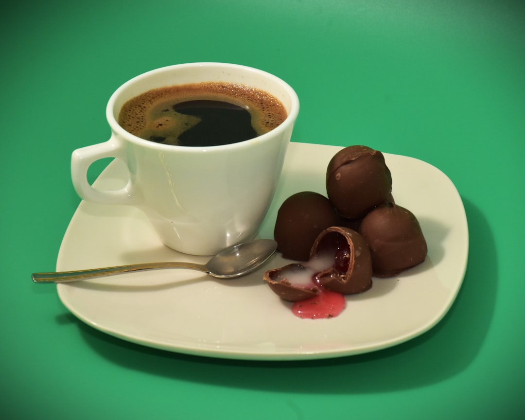 a-cup-of-coffee-with-chocolates-on-a-plate-d9r61su9m3s