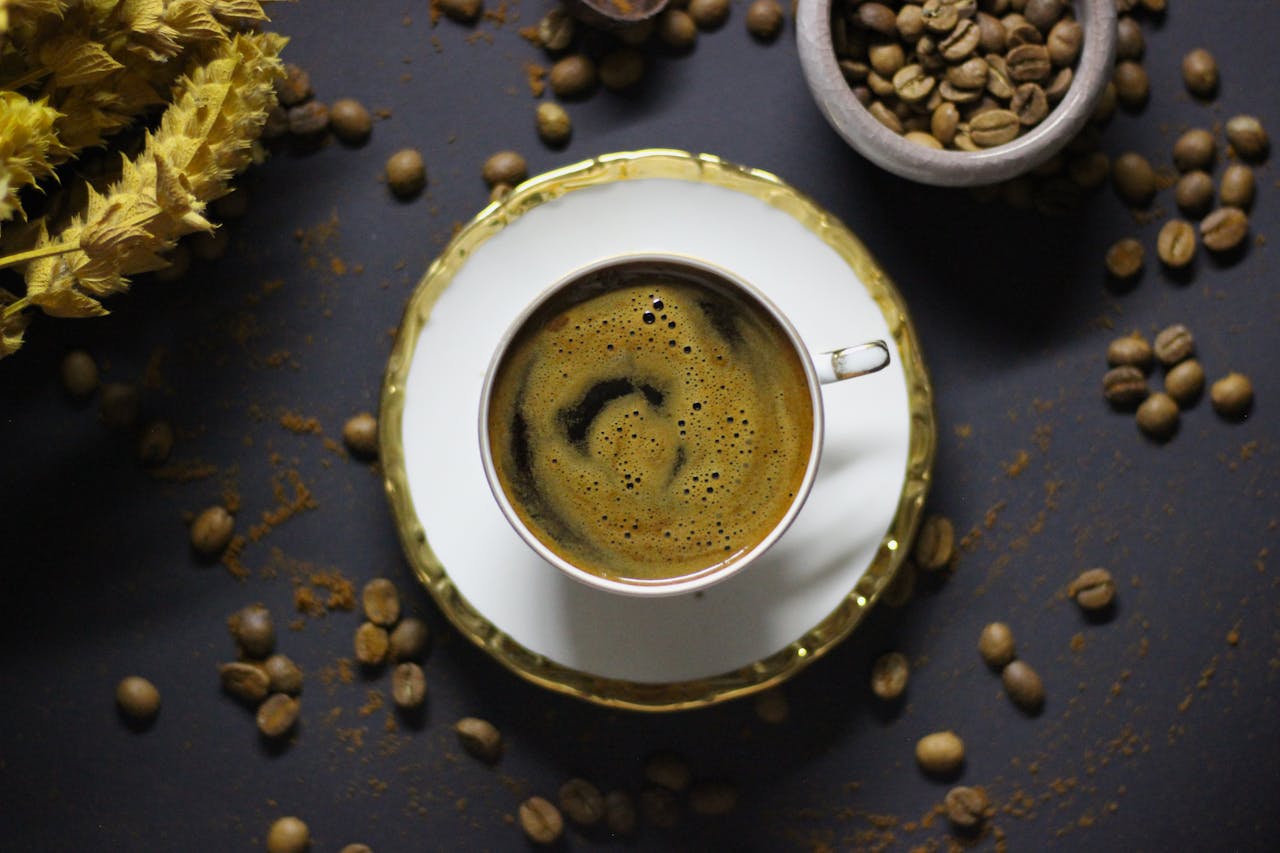 Aerial shot of Turkish coffee in a cup with saucer, surrounded by coffee beans.